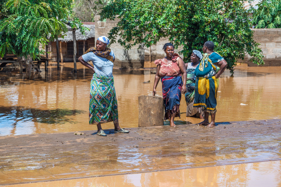 Women standing on a flooded street in Tanzania.
